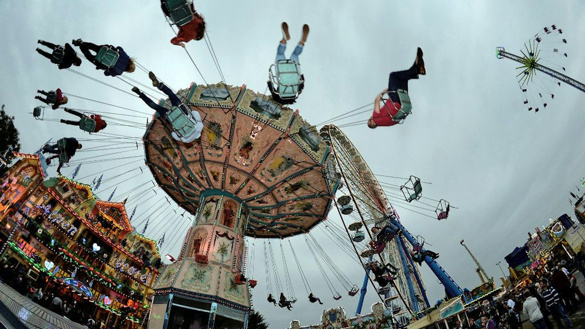 Besucher fahren in Bonn bei „Pützchens Markt“ mit einem Kettenkarussell.