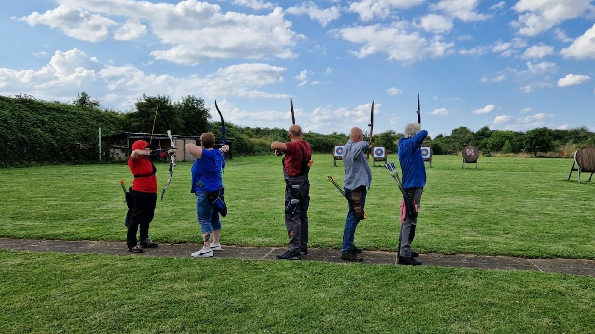 Bogenschützen trainieren auf einer Bogensportanlage mit mehreren Zielscheiben.
