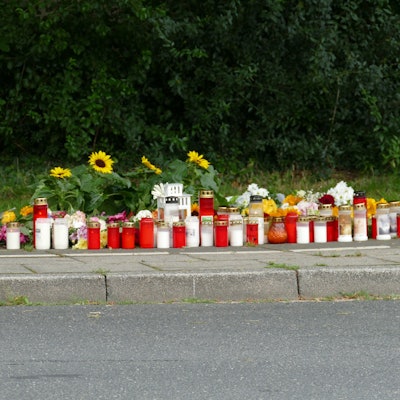 Menschen stehen an einer Gedenkstätte.