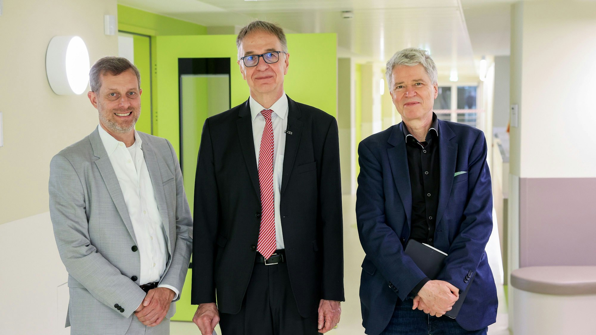 Im Kinderkrankenhaus stehen der Aufsichtsratschef der Kölner Kliniken, Ralf Unna, der ärztliche Direktor des Kinderkrankenhauses, Michael Weiß, und Gesundheitsdezernent Harald Rau.