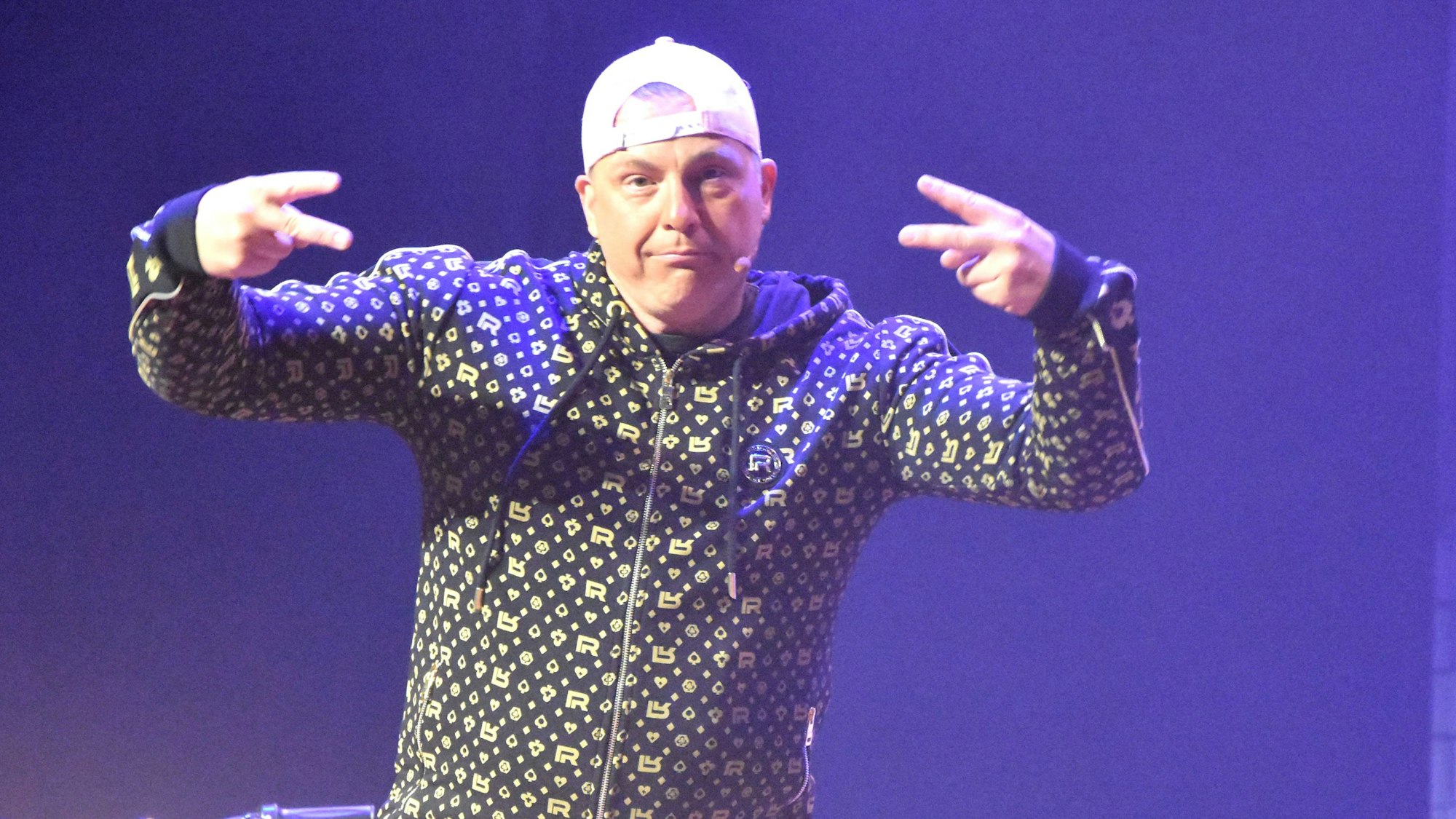 Auf dem Foto ist der Komiker Martin Klempnow in seiner Rolle als „Dennis aus Hürth“ zu sehen.