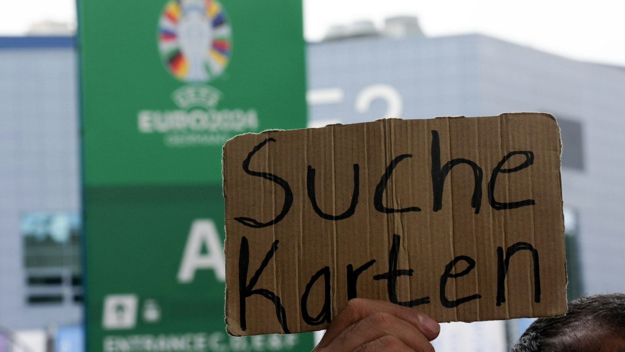 Ein Schild mit der Aufschrift „Suche Karten“ wird hochgehalten.