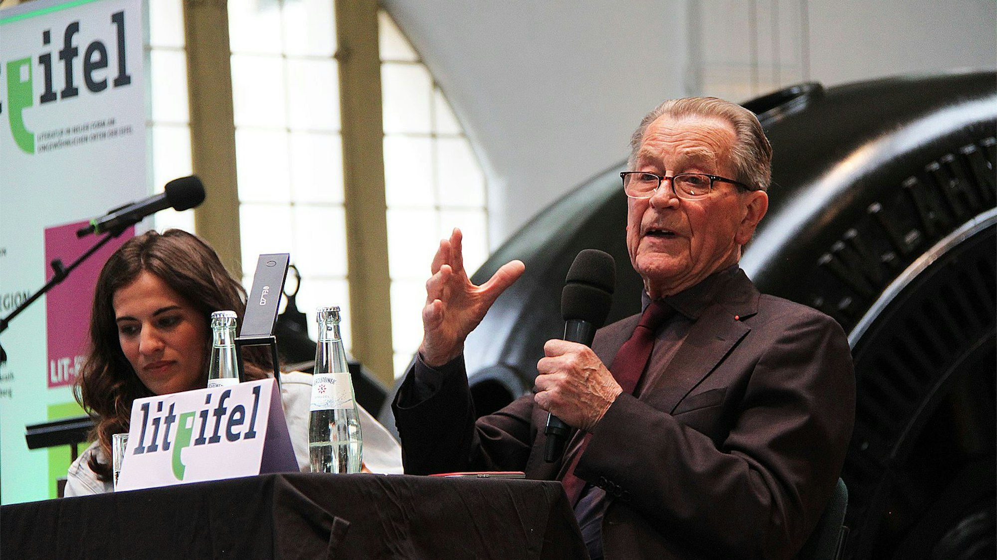 Franz Müntefering spricht in ein Mikrofon, neben ihm Moderatorin Mona Ameziane.