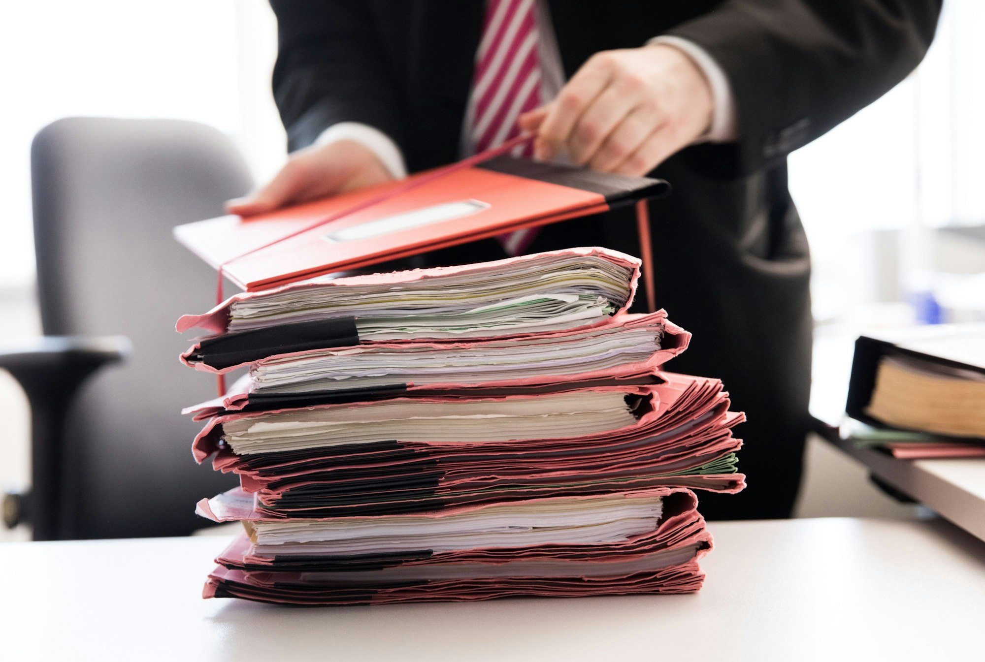 Ein Staatsanwalt bindet einen Stapel Gerichtsakten bei der Generalstaatsanwaltschaft zusammen.