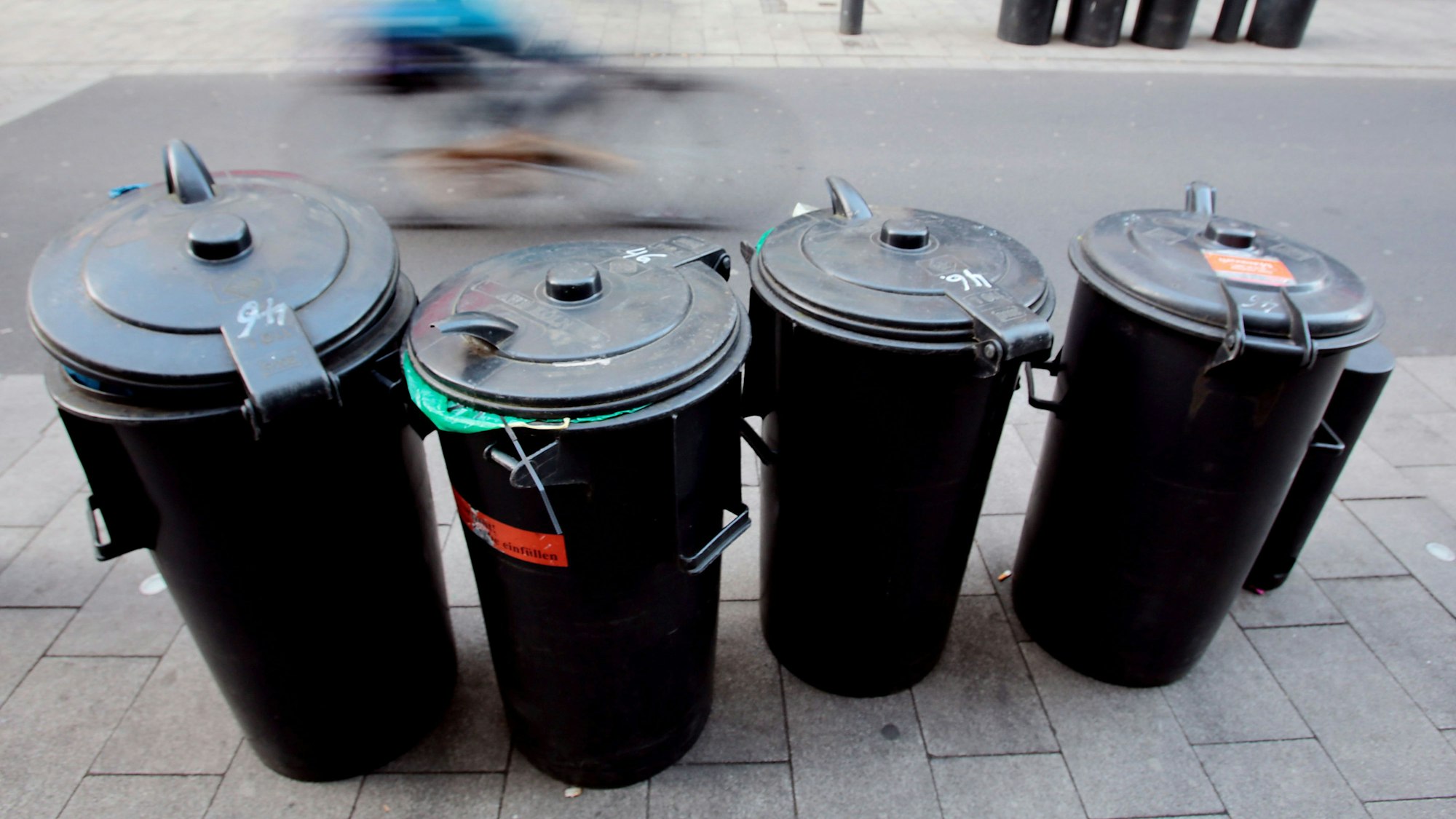 Mülltonnen stehen am Straßenrand in Köln.