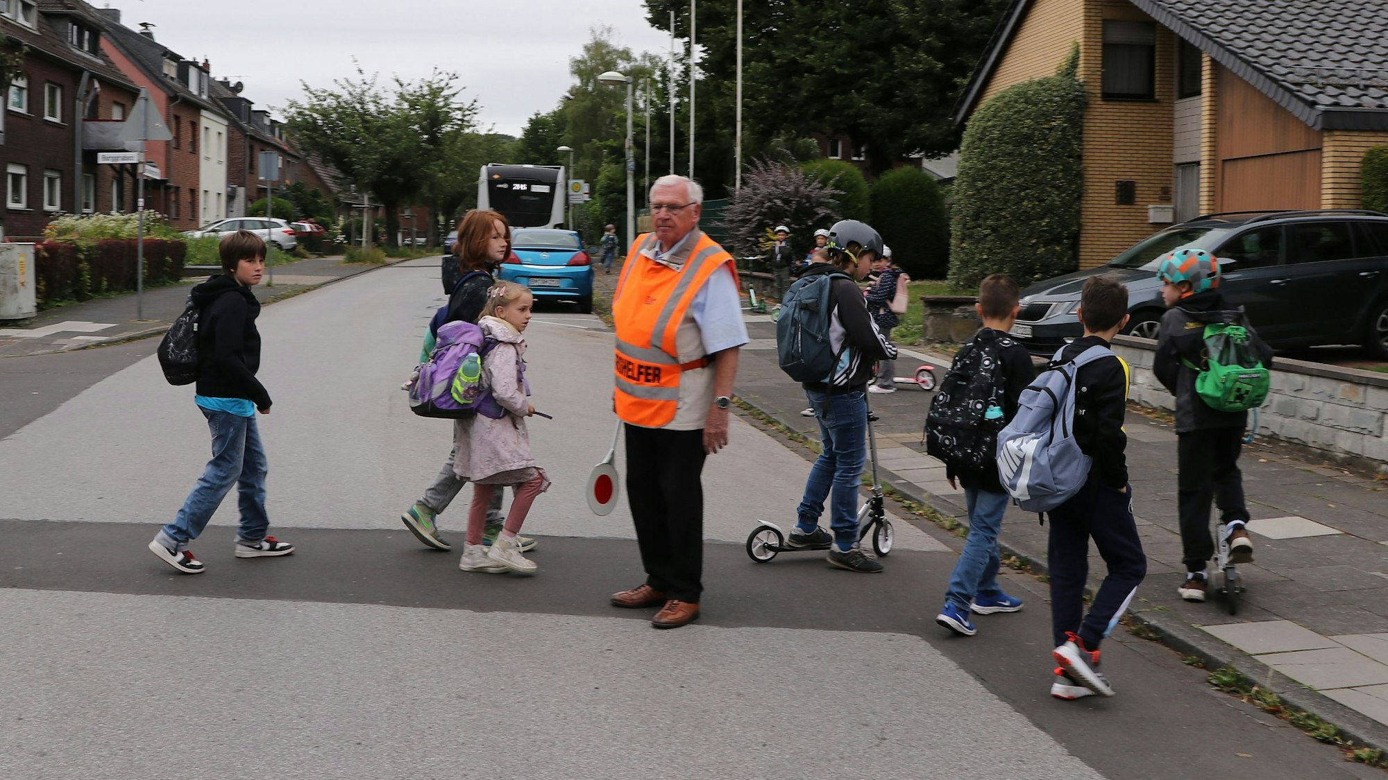 Auf dem Bild sind Kinder zu sehen, die Franz Becker sicher über die Straße geleitet.