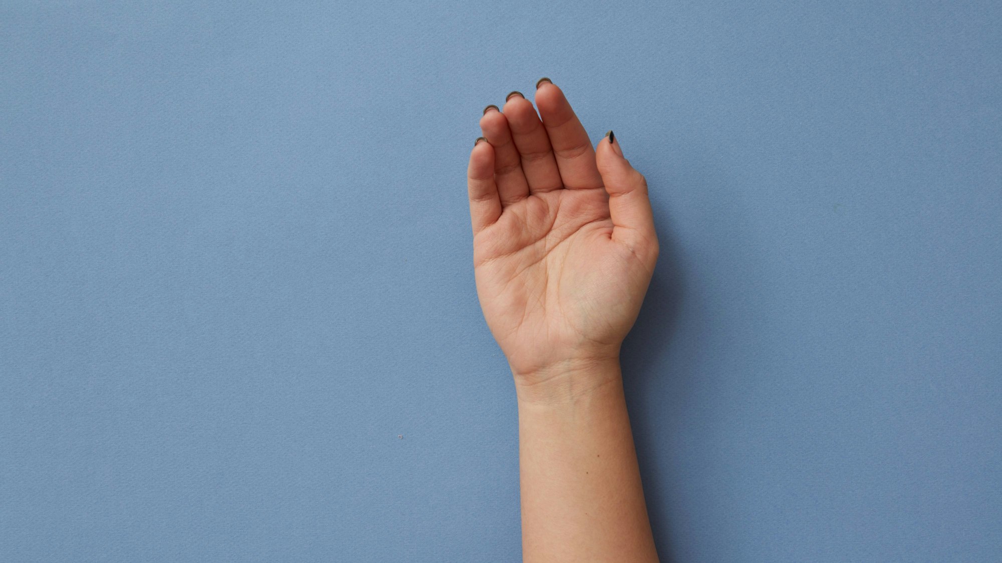 Eine gebeugte Hand, in der Falten zu erkennen sind