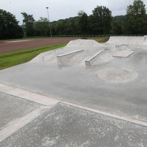 Eine Betonfläche mit Buckeln, Rampen und Geländer für Skater und BMX-Fahrräder.