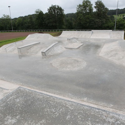 Eine Betonfläche mit Buckeln, Rampen und Geländer für Skater und BMX-Fahrräder.