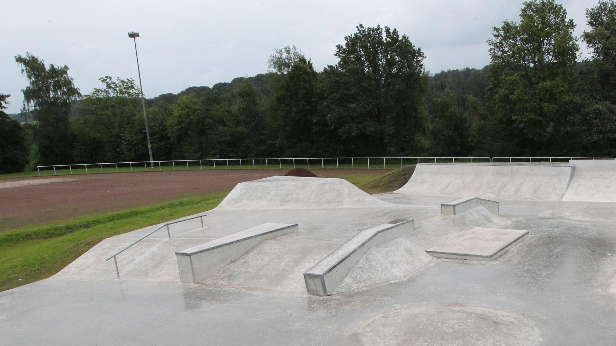 Eine Betonfläche mit Buckeln, Rampen und Geländer für Skater und BMX-Fahrräder.
