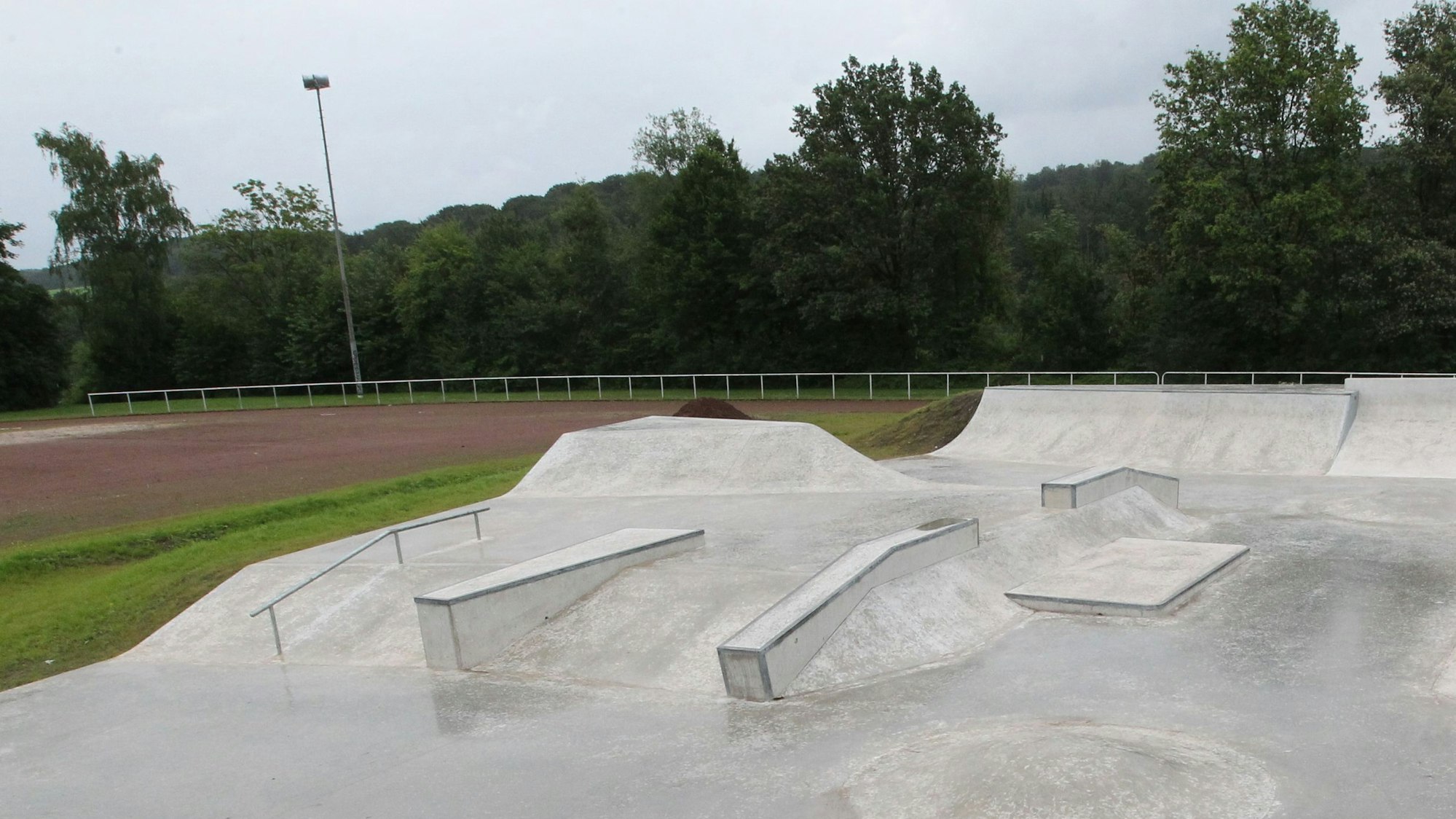 Eine Betonfläche mit Buckeln, Rampen und Geländer für Skater und BMX-Fahrräder.