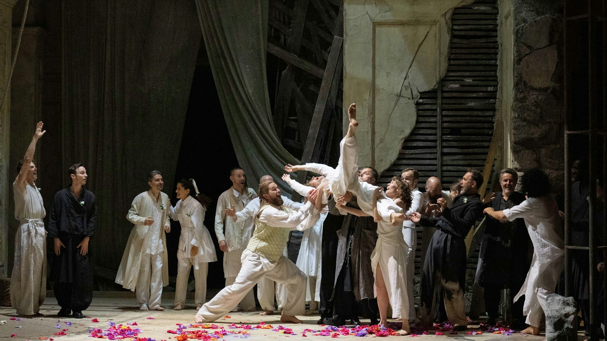 Menschen tummeln sich auf einer Opernbühne.