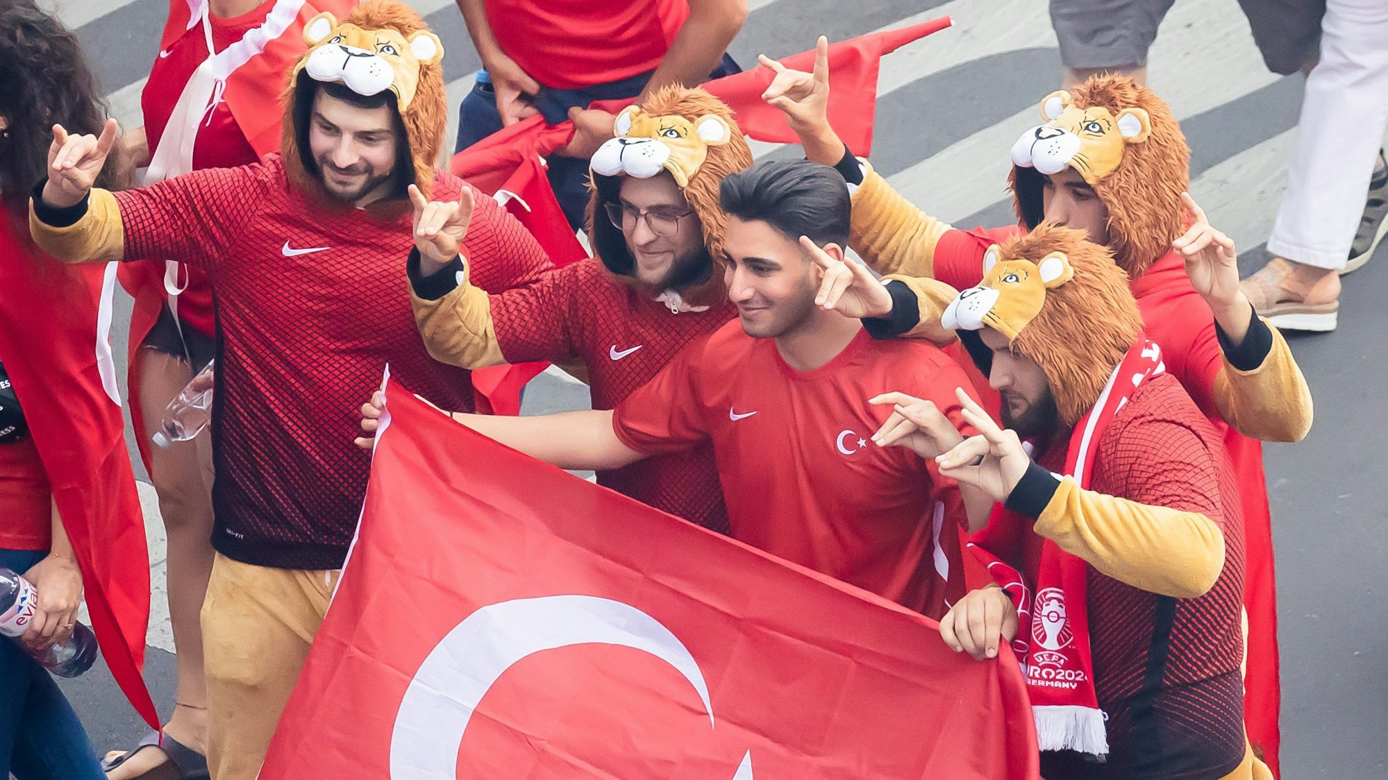 Türkei-Fans zeigen beim Fanmarsch Richtung Olympiastadion den „Wolfsgruß“, dessen Ursprung einer rechtsextremistischen Bewegung zugeordnet wird.