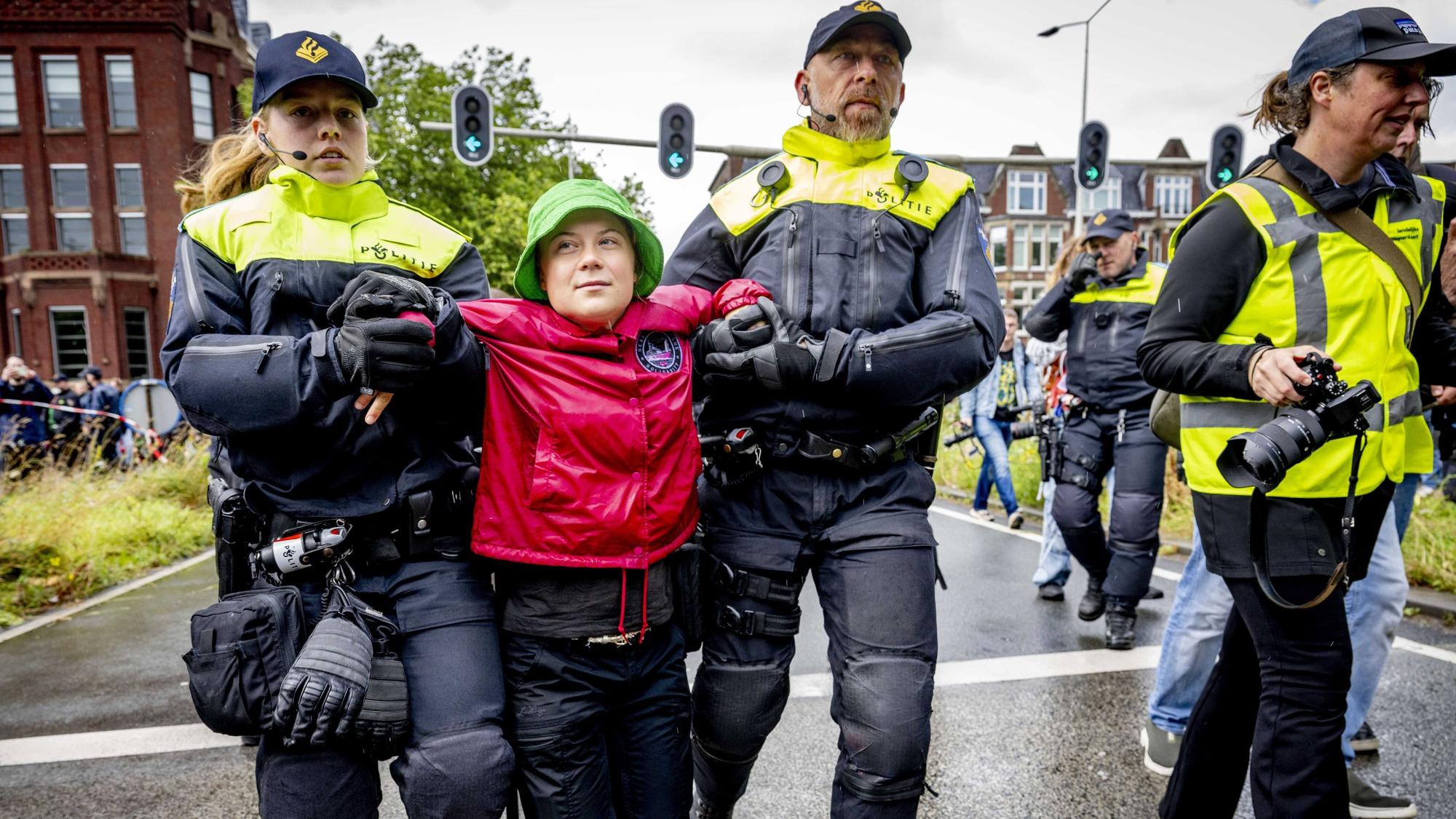 Niederlande, Den Haag: Klimaaktivistin Greta Thunberg (M) wird bei einer Demonstration der Umweltinitiative Extinction Rebellion (XR), die eine Auffahrt zur Autobahn A12 blockiert, von Polizeibeamten abgeführt.