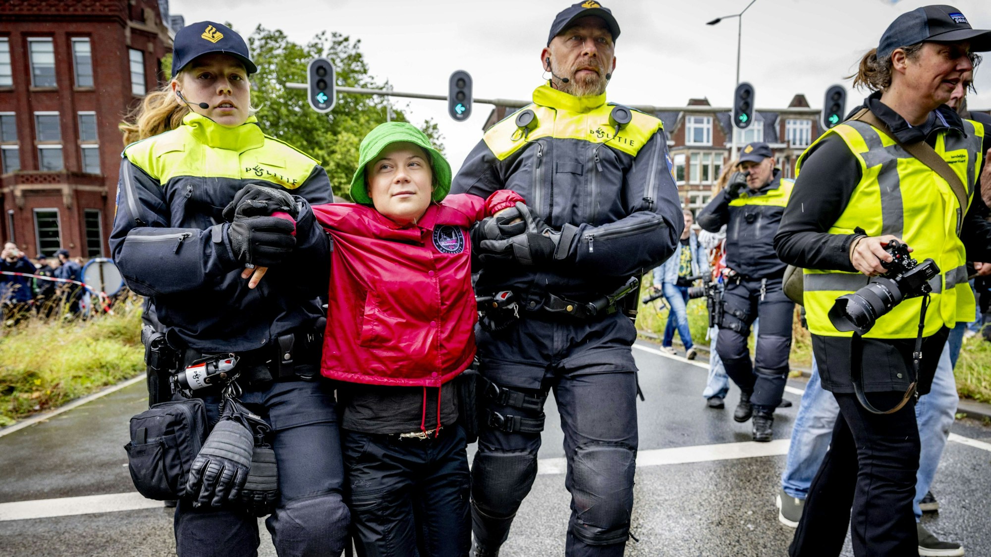 Niederlande, Den Haag: Klimaaktivistin Greta Thunberg (M) wird bei einer Demonstration der Umweltinitiative Extinction Rebellion (XR), die eine Auffahrt zur Autobahn A12 blockiert, von Polizeibeamten abgeführt.