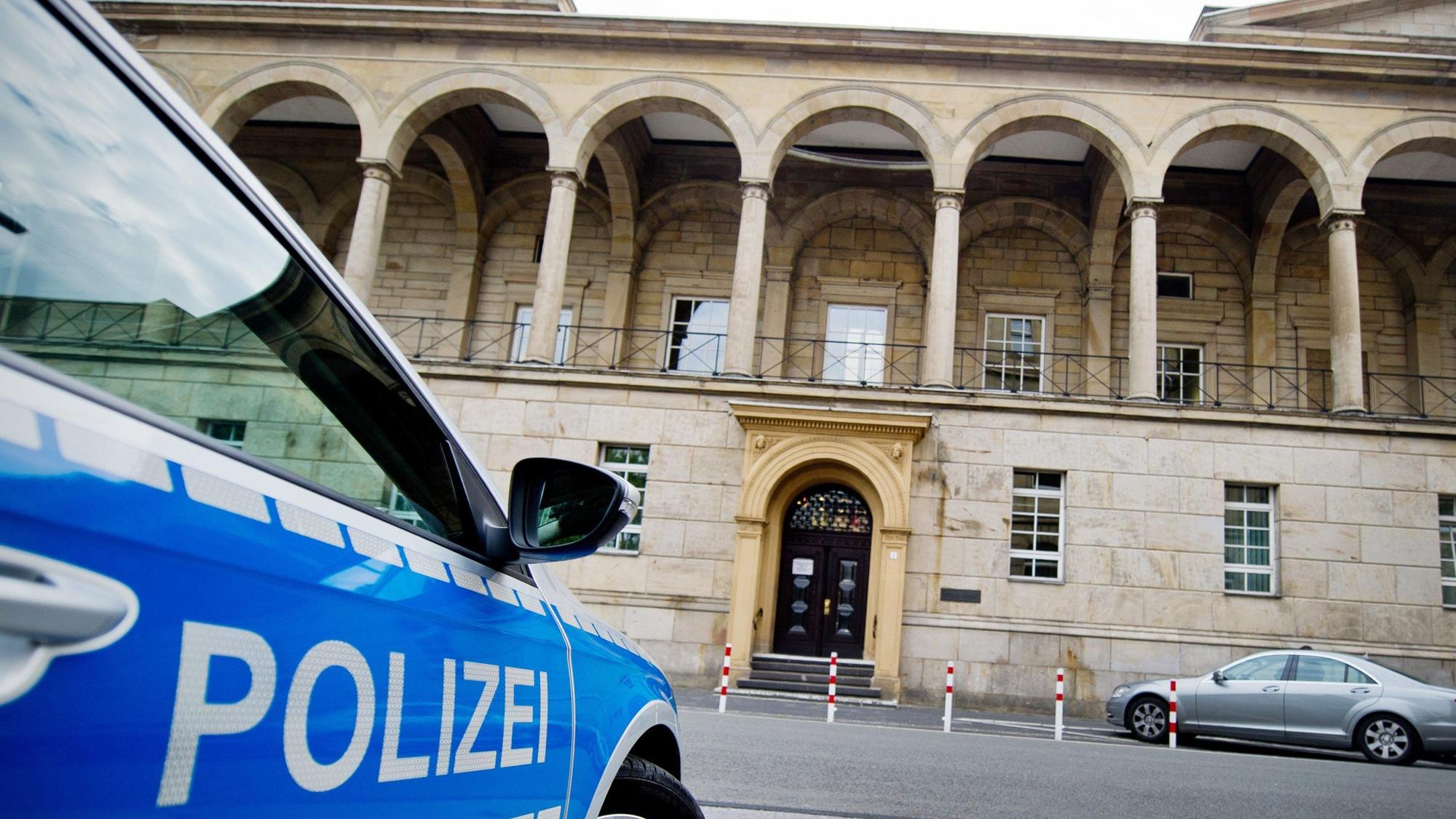 Ein Polizeifahrzeug steht vor dem Landgericht.