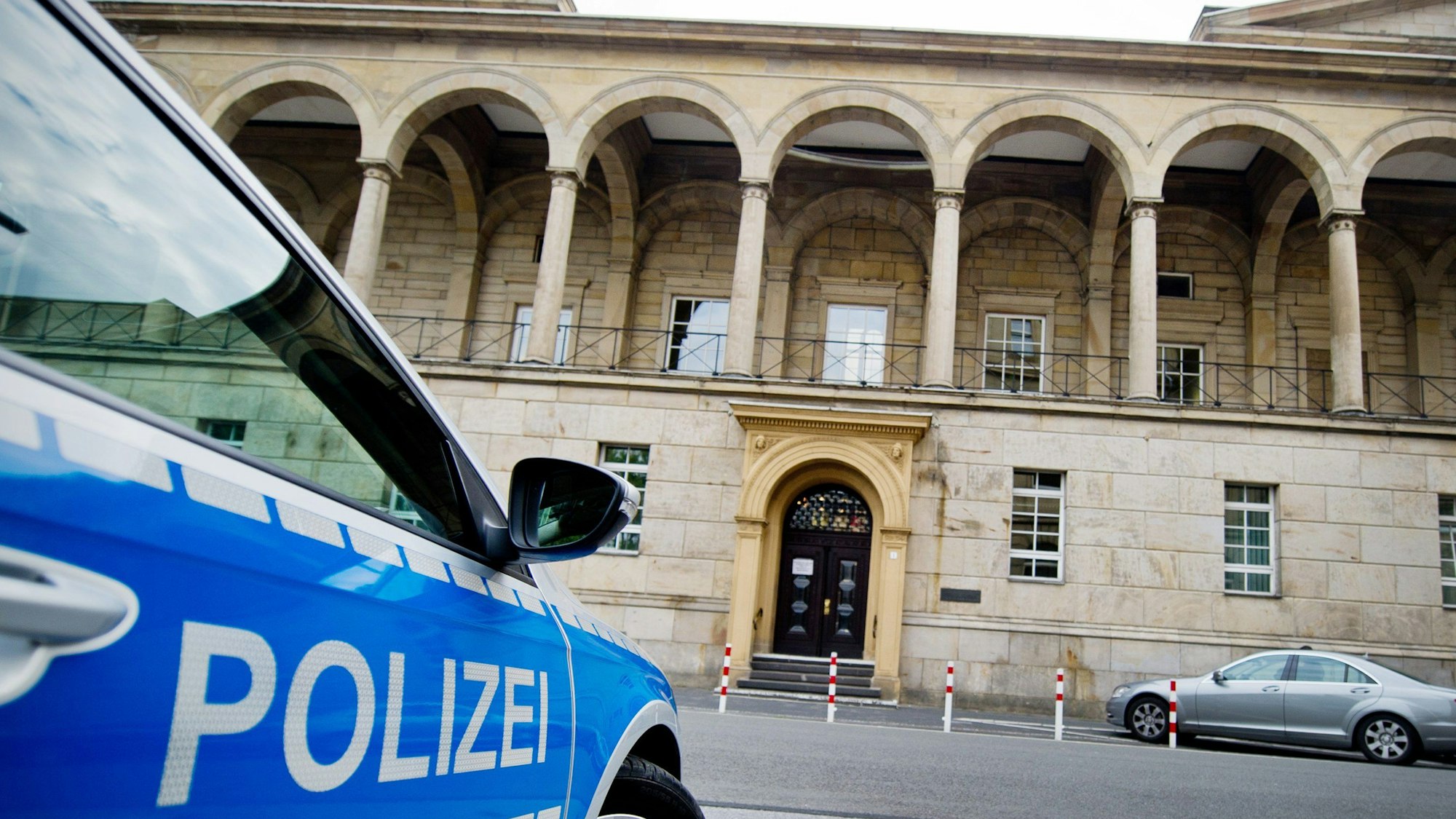 Ein Polizeifahrzeug steht vor dem Landgericht.