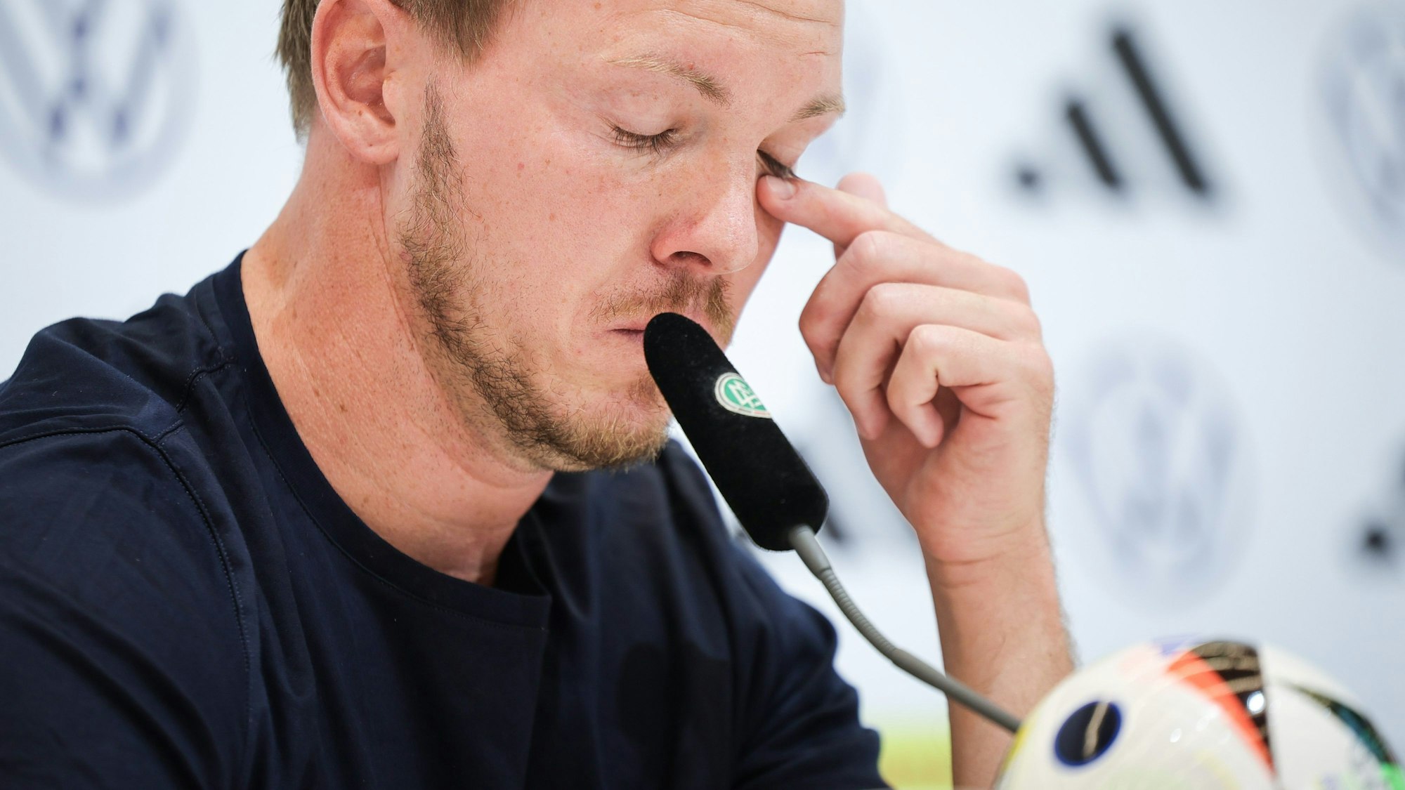 06.07.2024, Bayern, Herzogenaurach: Fußball: EM, Pressekonferenz nach dem Ausscheiden der deutschen Nationalmannschaft, Bundestrainer Julian Nagelsmann kämpft mit den Tränen bei der Abschluss-Pressekonferenz. Foto: Christian Charisius/dpa +++ dpa-Bildfunk +++