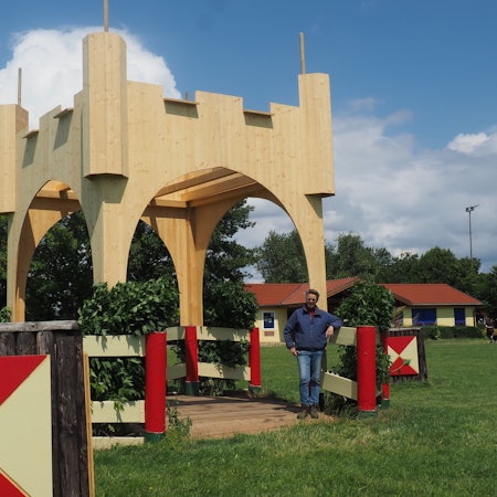 Dorit Santema steht am Medardus-Tor, einer imposanten Holzkonstruktion auf dem Gelände des Vereins.