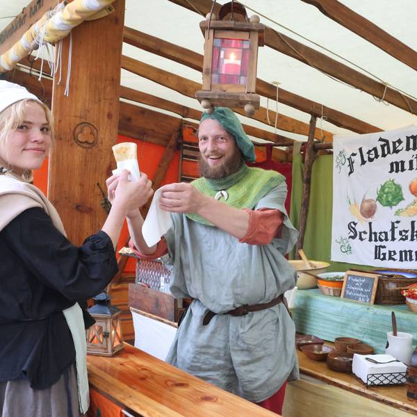 Mittelaltermarkt Denklingen, Kundin Merle kauft ein gefülltes Fladenbrot bei Martin Edelmann.