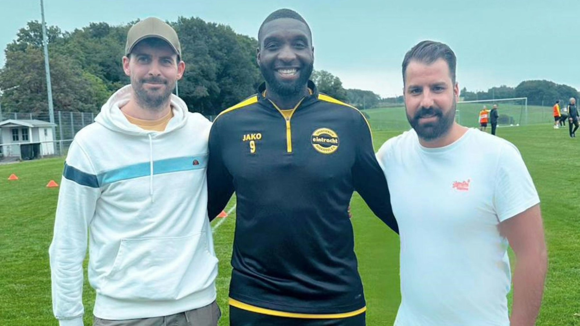 Gruppenbild mit zwei Funktionären und einem Fußballspieler