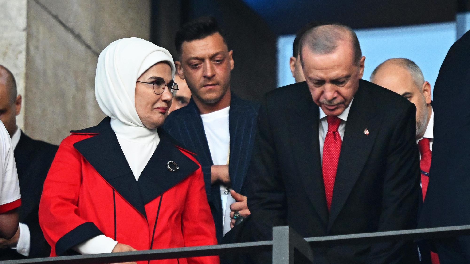Mesut Özil (M), ehemaliger deutscher Nationalspieler, steht hinter Recep Tayyip Erdogan (r), Präsident der Türkei, und seiner Frau Emine Erdogan (l) vor dem EM-Spiel auf der Tribüne in Berlin bei der EM 2024.