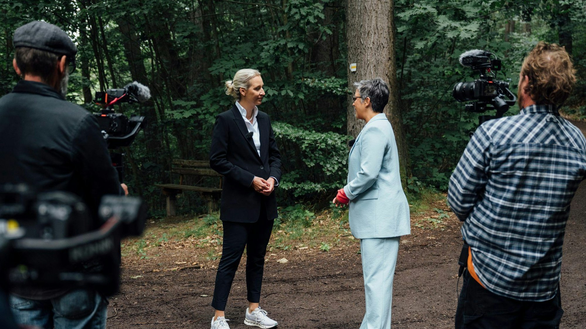 Alice Weidel (l.), Bundesvorsitzende der AfD, unterhält sich am Rande des ZDF-Sommerinterviews in „Berlin direkt“ in einem Wald am sogenannten „Geographischen Mittelpunkt Sachsens“ mit Moderatorin Shakuntala Banerjee.