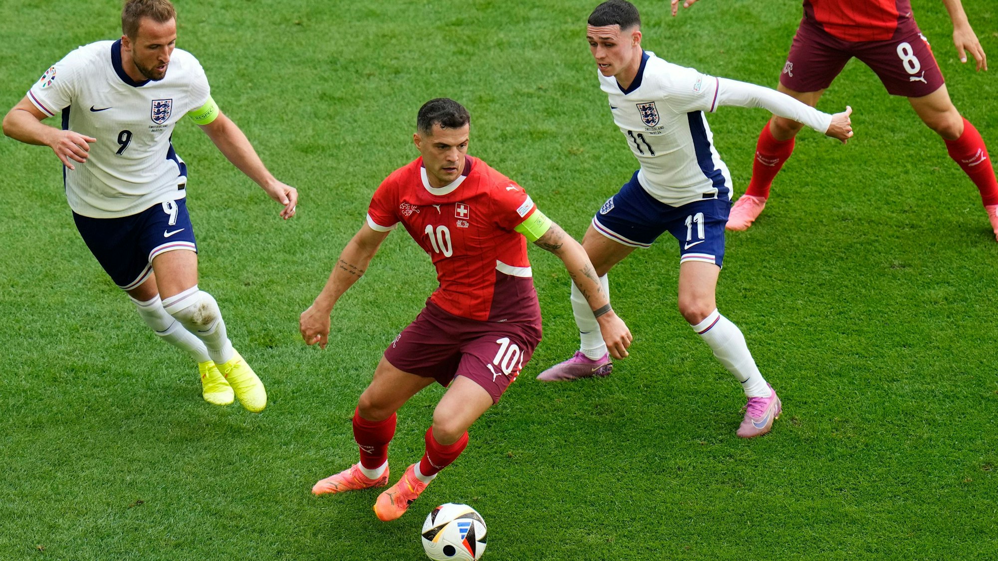 Schweiz-Kapitän Granit Xhaka verteidigt den Ball vor den Angriffen der Engländer Harry Kane (l.) und Phil Foden.