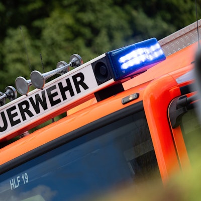 Blaulicht ist während eines Brandes auf einem Einsatzfahrzeug der Feuerwehr zu sehen.