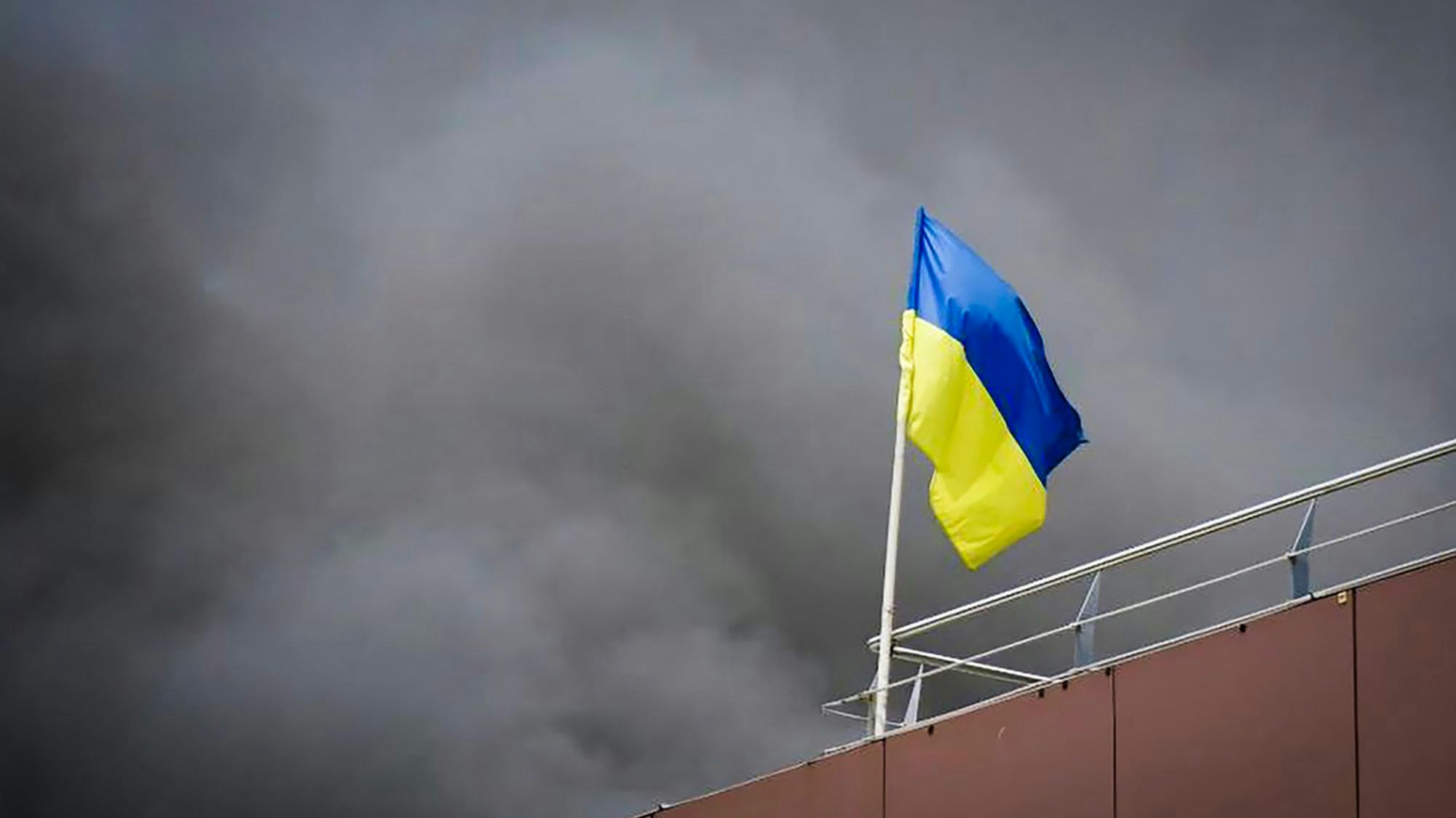 Ukraine, Dnipro: Auf diesem von der Regionalverwaltung Dnipro veröffentlichten Foto weht die ukrainische Flagge, während nach einem russischen Raketenangriff Rauch aufsteigt.