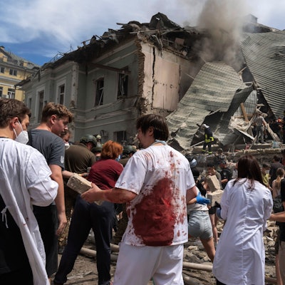 Kiew: Rettungskräfte, Freiwillige und medizinisches Personal, einige in blutverschmierten Uniformen, räumen die Trümmer auf und suchen nach Opfern, nachdem eine russische Rakete das Okhmatdyt-Kinderkrankenhaus getroffen hat