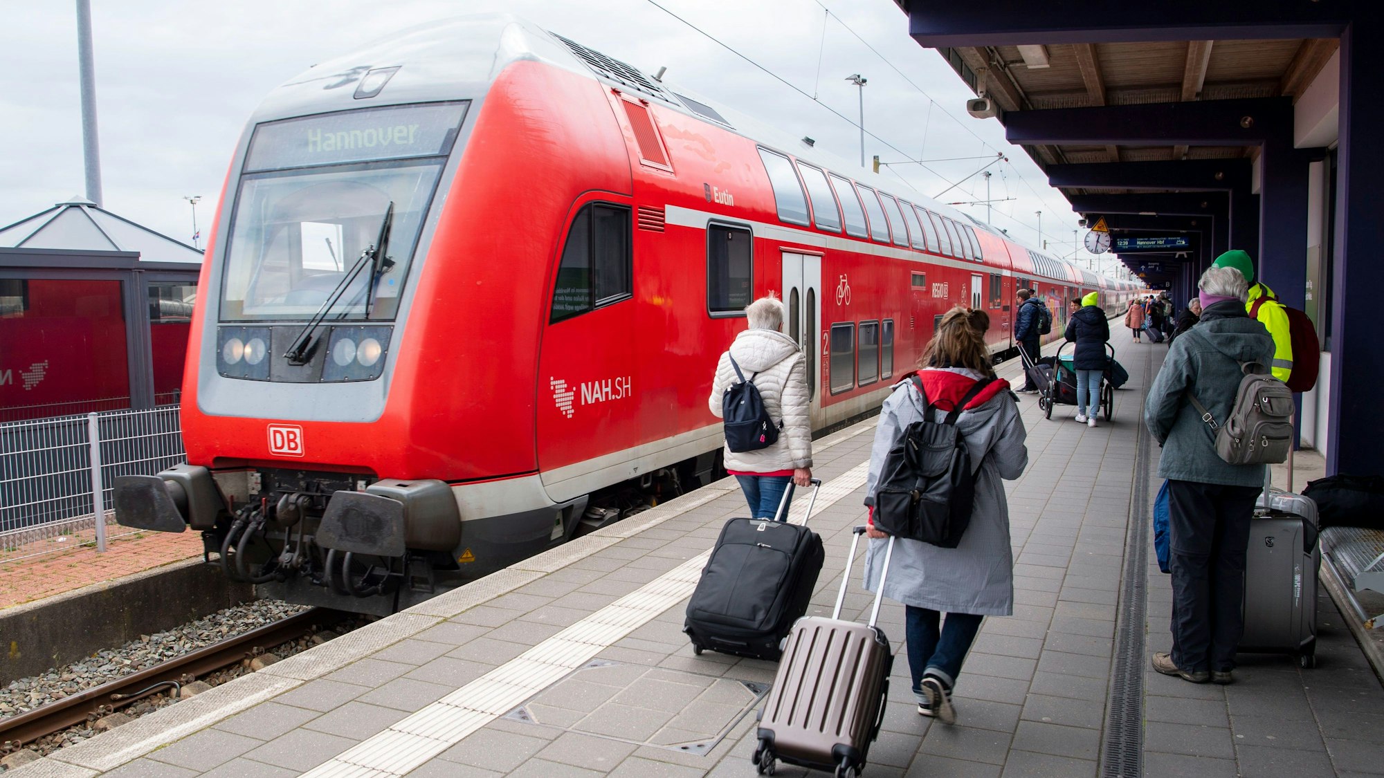 ARCHIV - 27.04.2023, Niedersachsen, Norddeich: Touristen laufen mit Rollkoffern am Bahnhof Norddeich-Mole entlang. (zu dpa: «Minister fordert Klarheit über Preis von Deutschlandticket») Foto: Philip Dulian/dpa +++ dpa-Bildfunk +++