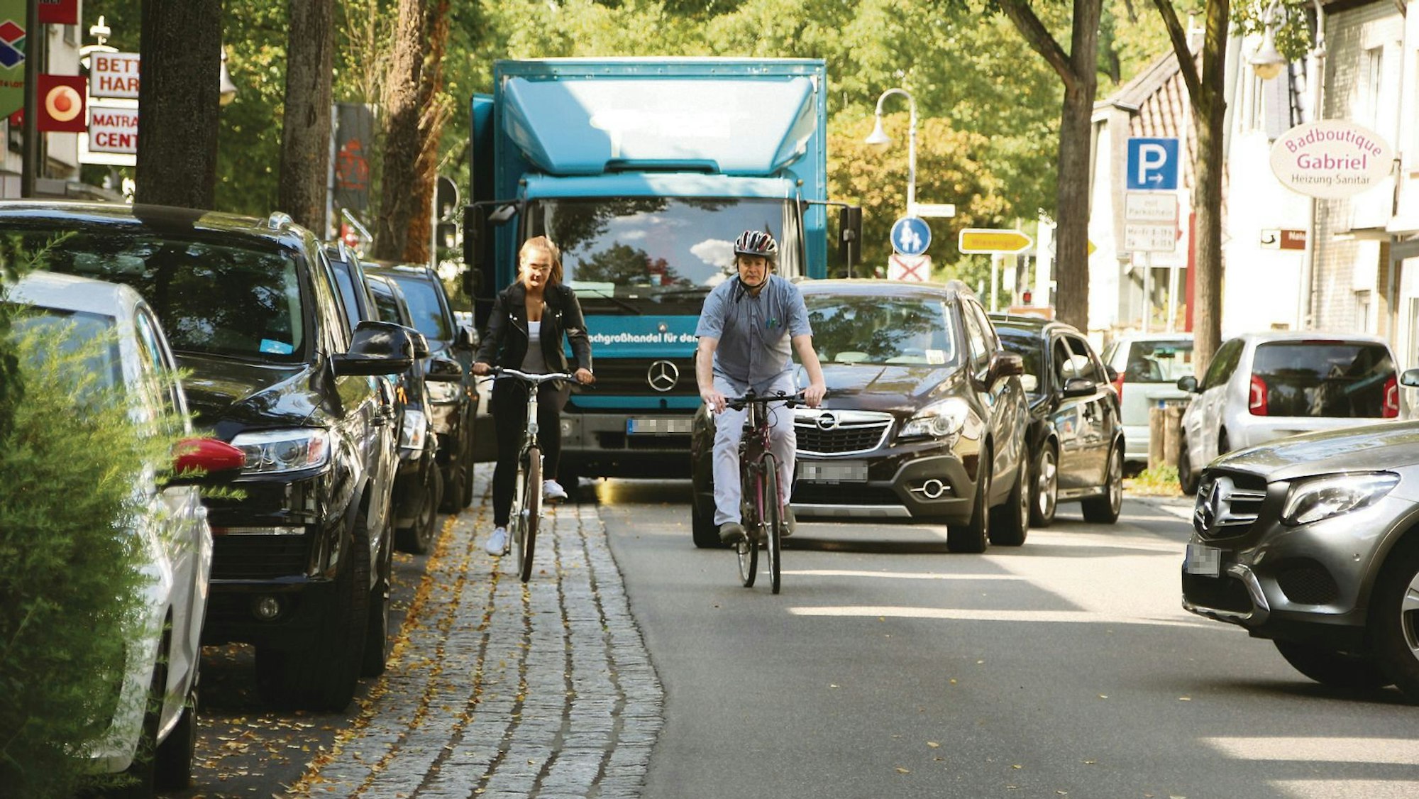 Die viel befahrene Frankfurter Straße in der Hennefer Innenstadt mit Autos, Lkw und zwei Radlern.