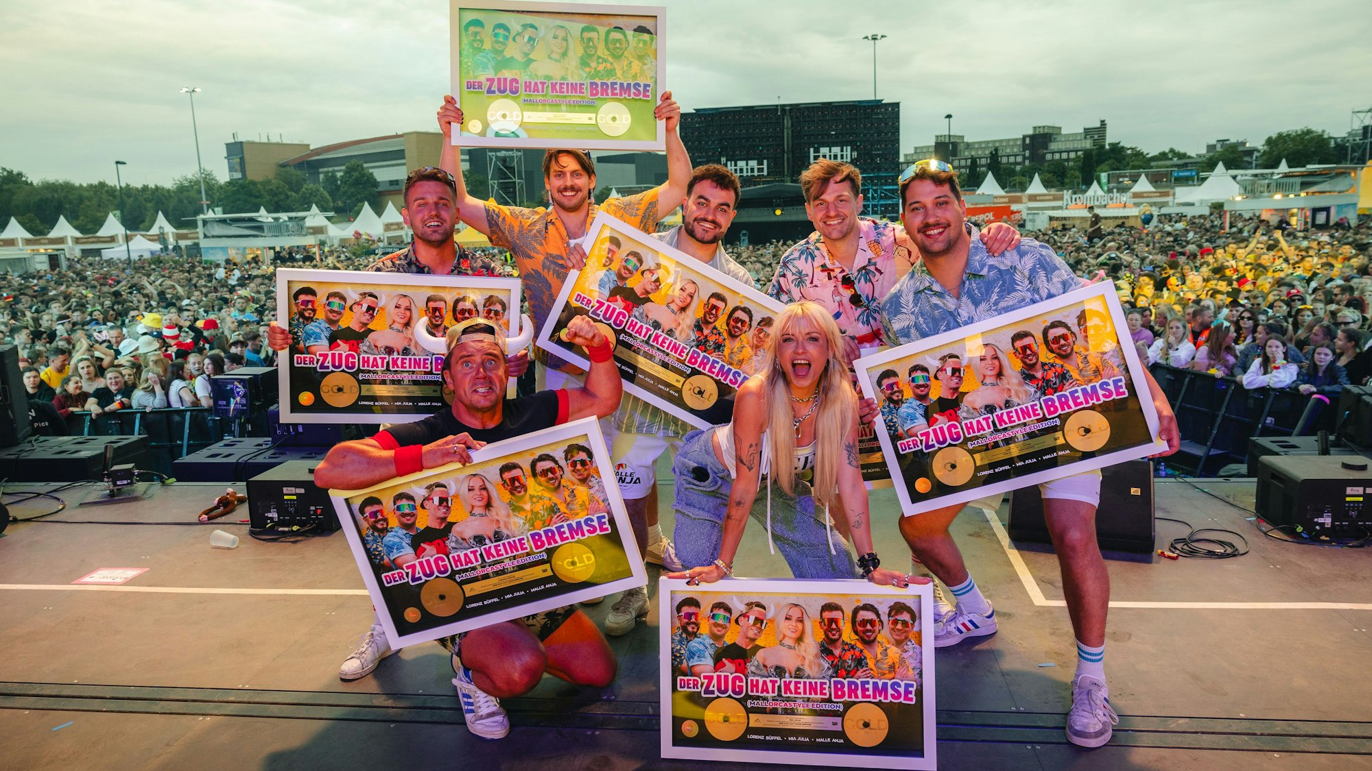 Die fünf Bandmitglieder, Mia Julia und Lorenz Büffel stehen mit der Auszeichnung auf einer Bühne.