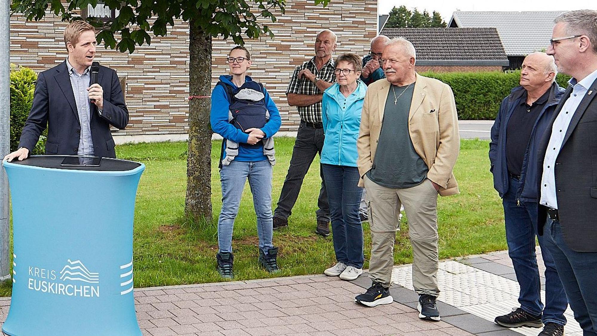 Landrat Markus Ramers steht an einem Pult und spricht zu einigen Leuten.