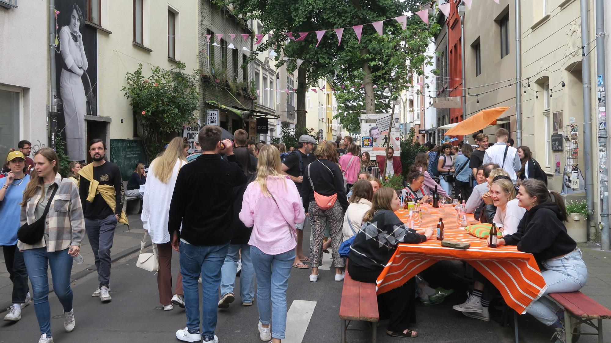 Besucherinnen und Besucher gehen die Körnerstraße beim Körnerstraßenfest in Köln-Ehrenfeld entlang.