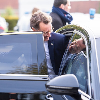 18.10.2023 - Hendrik Wüst besucht neue Flüchtlingsunterkunft in Halle/Westfalen: Der NRW-Ministerpräsident CDU bei einem von vier Terminen in Ostwestfalen-Lippe. In dieser fast fertiggestellten Unterkunft finden bis zu 60 Menschen Platz. Im Bild steigt er in seinen Dienstwagen ein. Sein Bild spiegelt sich. , *** 18 10 2023 Hendrik Wüst visits new refugee accommodation in Halle Westphalia The NRW Minister President CDU at one of four appointments in East Westphalia Lippe There is room for up to 60 people in this almost completed accommodation In the picture he gets into his official car His image is reflected ,