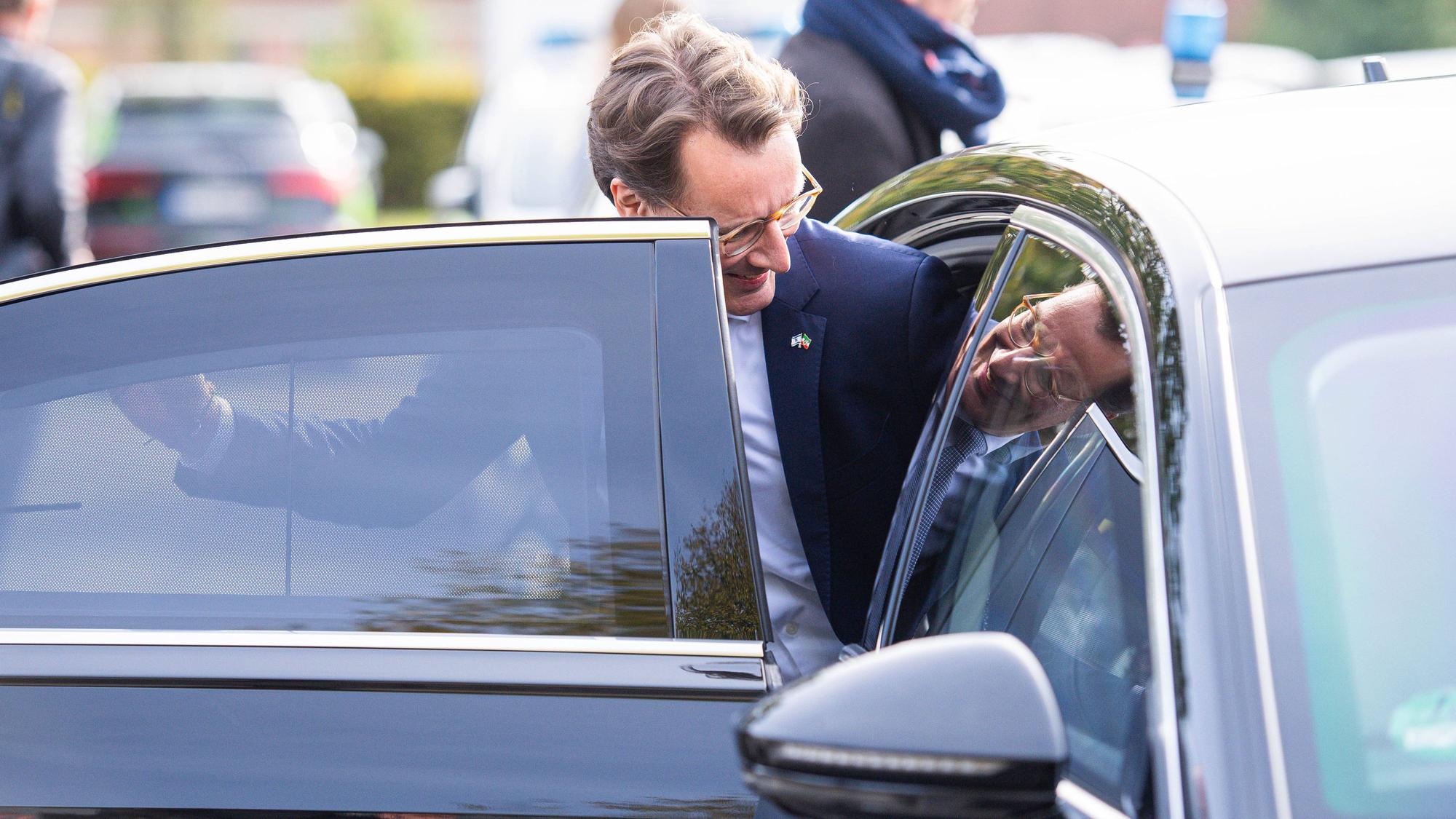 18.10.2023 - Hendrik Wüst besucht neue Flüchtlingsunterkunft in Halle/Westfalen: Der NRW-Ministerpräsident CDU bei einem von vier Terminen in Ostwestfalen-Lippe. In dieser fast fertiggestellten Unterkunft finden bis zu 60 Menschen Platz. Im Bild steigt er in seinen Dienstwagen ein. Sein Bild spiegelt sich. , *** 18 10 2023 Hendrik Wüst visits new refugee accommodation in Halle Westphalia The NRW Minister President CDU at one of four appointments in East Westphalia Lippe There is room for up to 60 people in this almost completed accommodation In the picture he gets into his official car His image is reflected ,