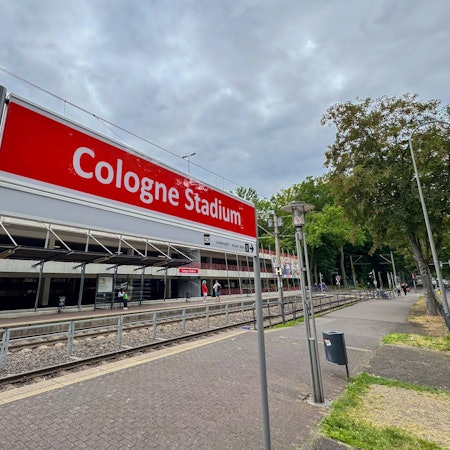 Das rot-weiße vorübergehende KVB-Haltestellenschild mit der Aufschrift „Cologne Stadium“ am Rhein-Energie-Stadion.
