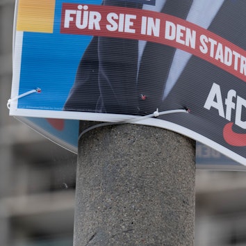 Ein Wahlplakat der AfD zur Kommunalwahl hängt vor einem Neubaublock in Halle/Saale. (Archivbild)