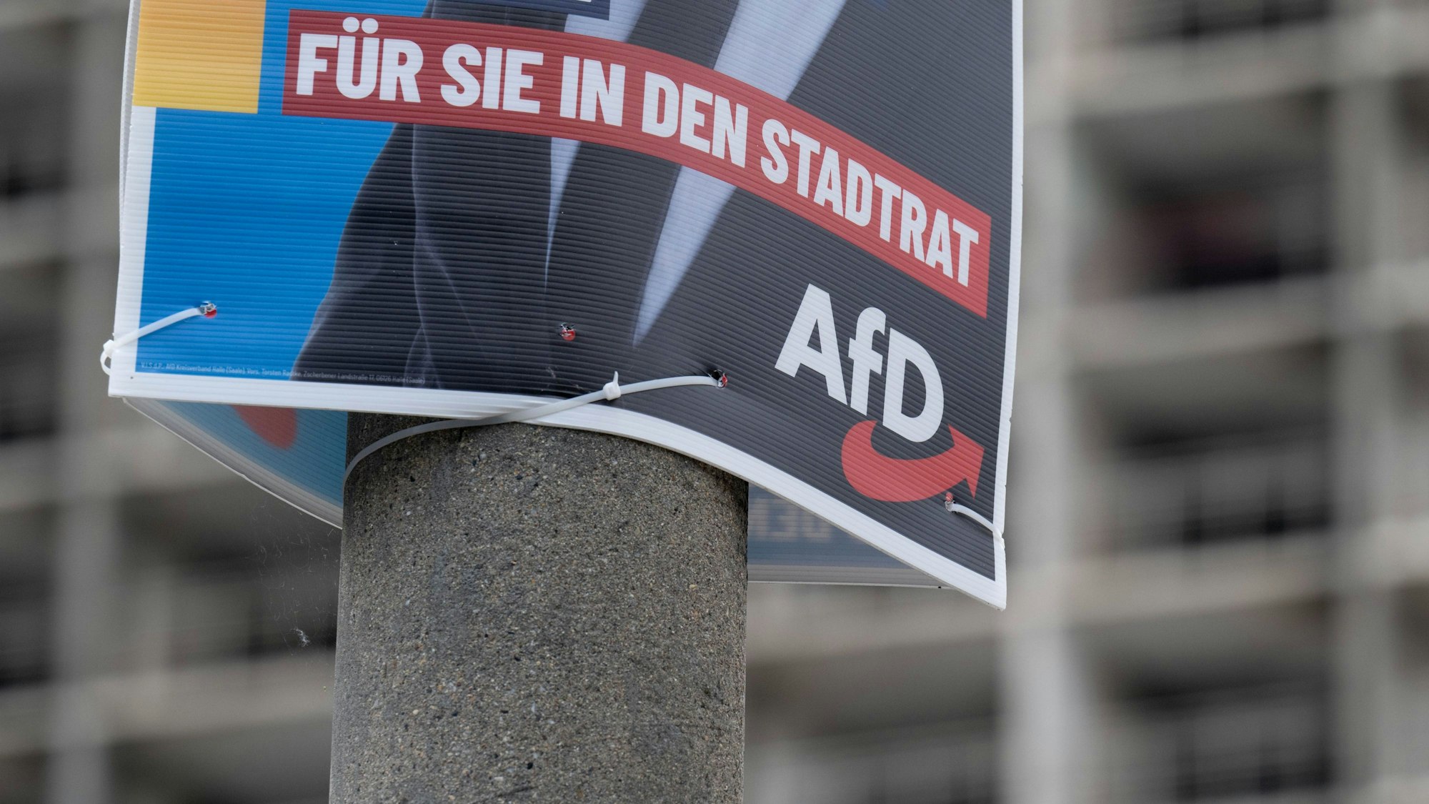 Ein Wahlplakat der AfD zur Kommunalwahl hängt vor einem Neubaublock in Halle/Saale. (Archivbild)