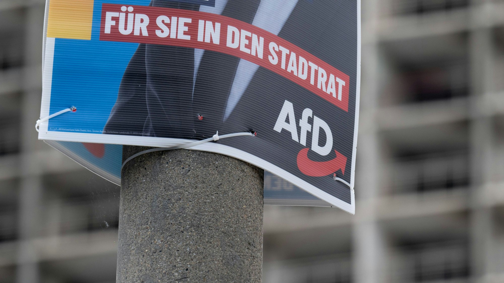 Ein Wahlplakat der AfD zur Kommunalwahl hängt vor einem Neubaublock in Halle/Saale. (Archivbild)