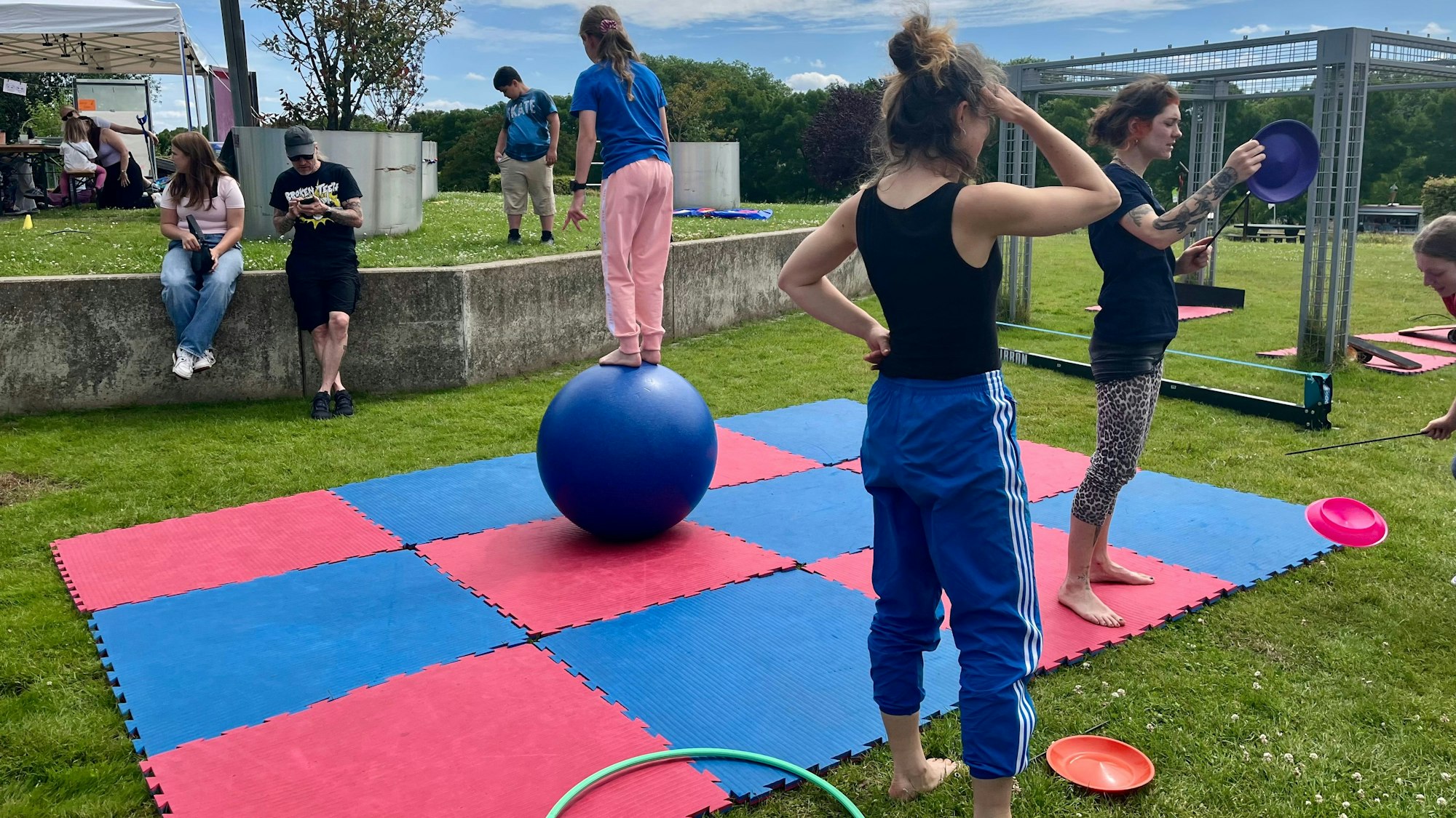 Ein Mädchen balanciert auf einem großen Ball auf einer Matte.
