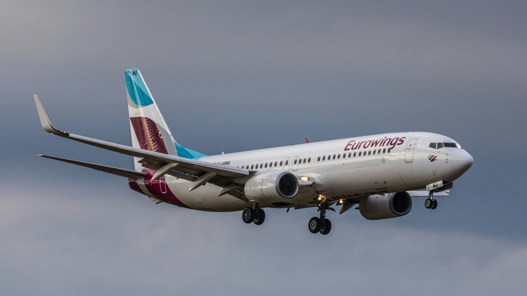 Eine Boeing 737 der deutschen Fluggesellschaft Eurowings im Landeanflug vor einem Unwetter. Am Flugzeug leuchten mehrere Warnleuchten. (Symbolbild)