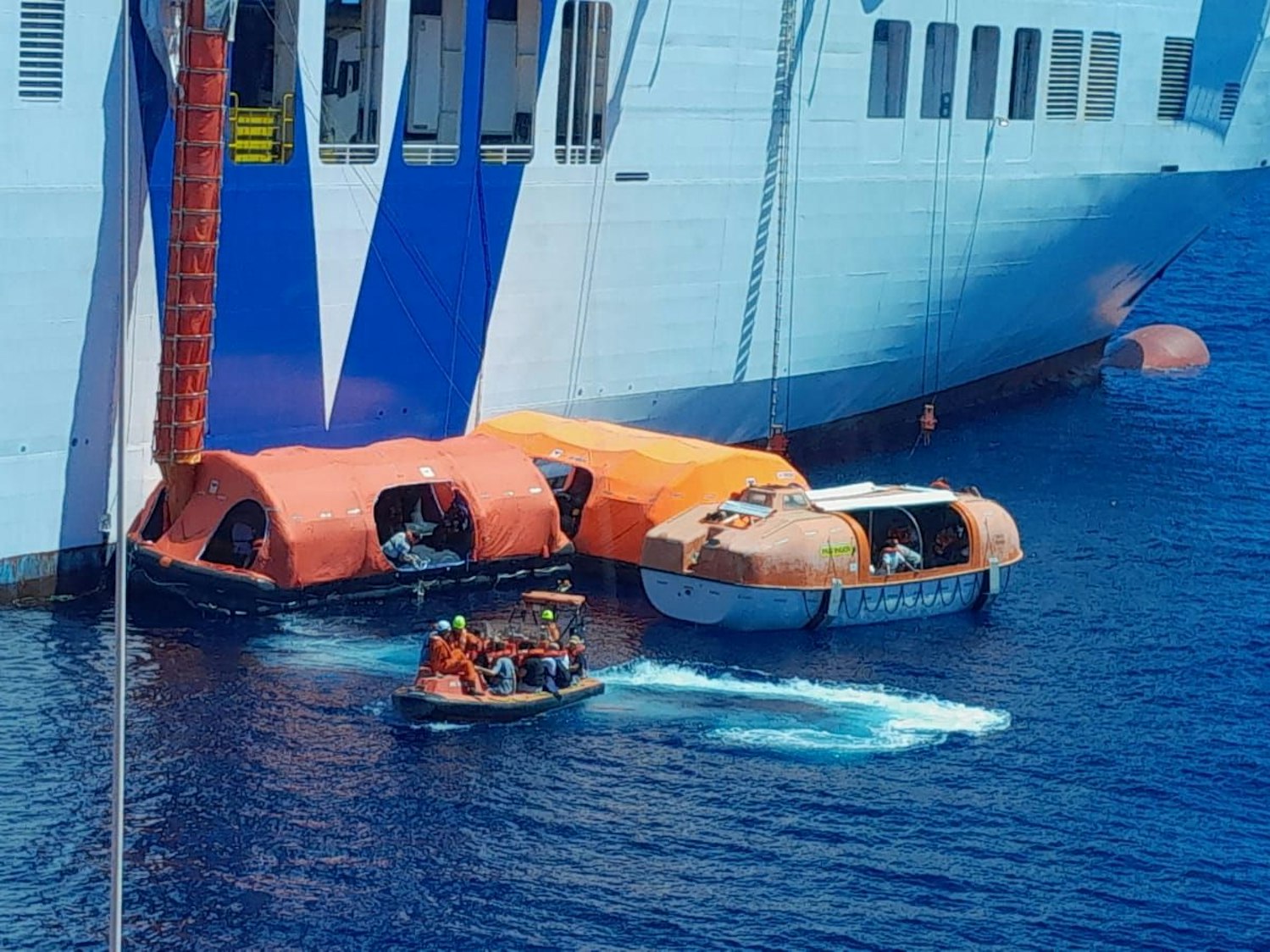 Passagiere mussten durch einen Rettungsschlauch auf kleinere Rettungsboote rutschen.