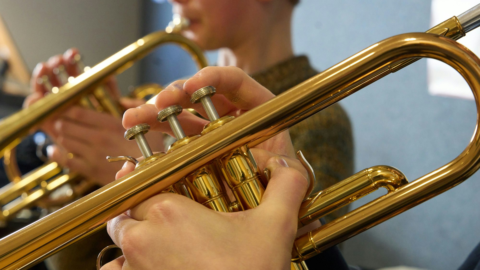 Zwei Jungen spielen im Unterricht an einer Musikschule Trompete.