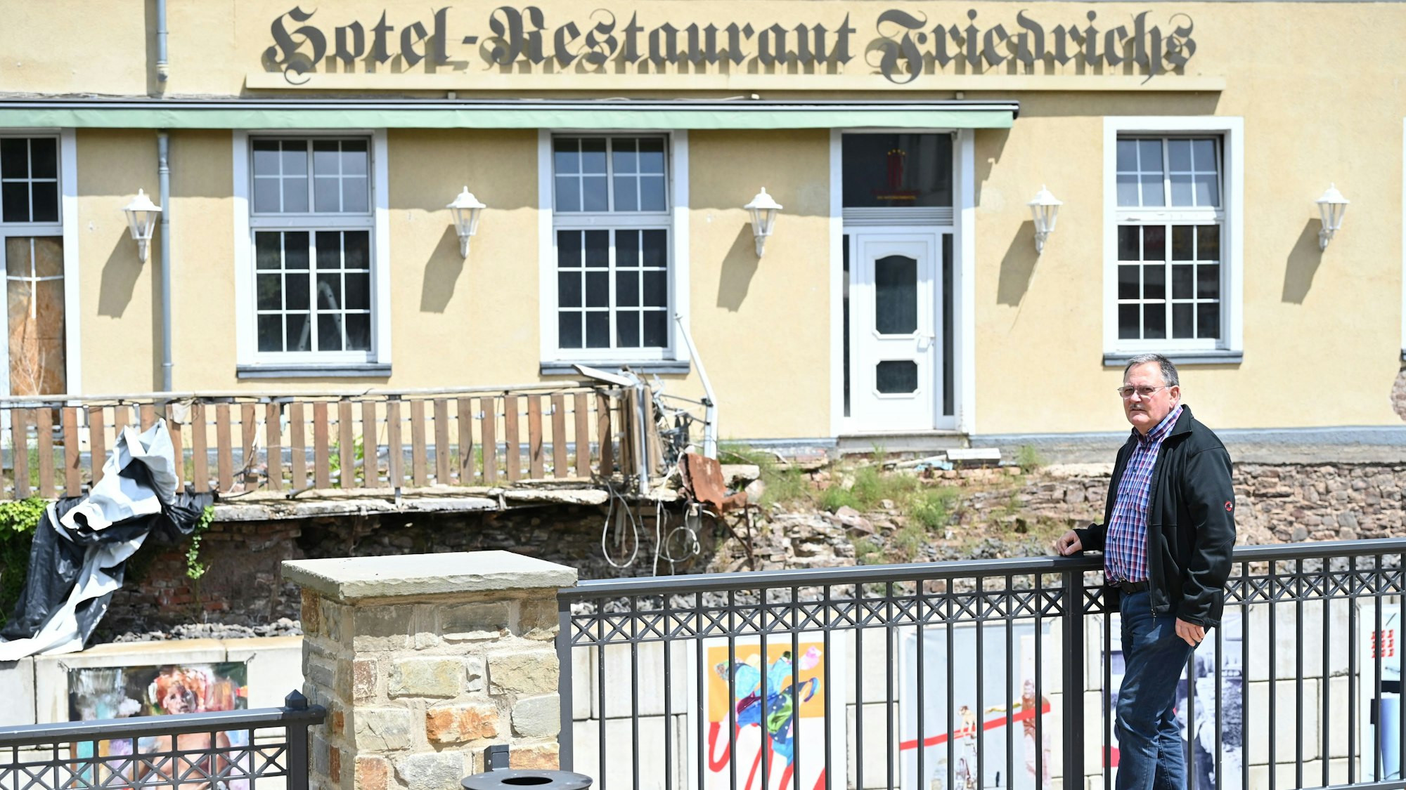 Franz Schockert steht in Gemünd vor dem Hotel Friedrichs, in dem der Wiederaufbau noch nicht begonnen hat.