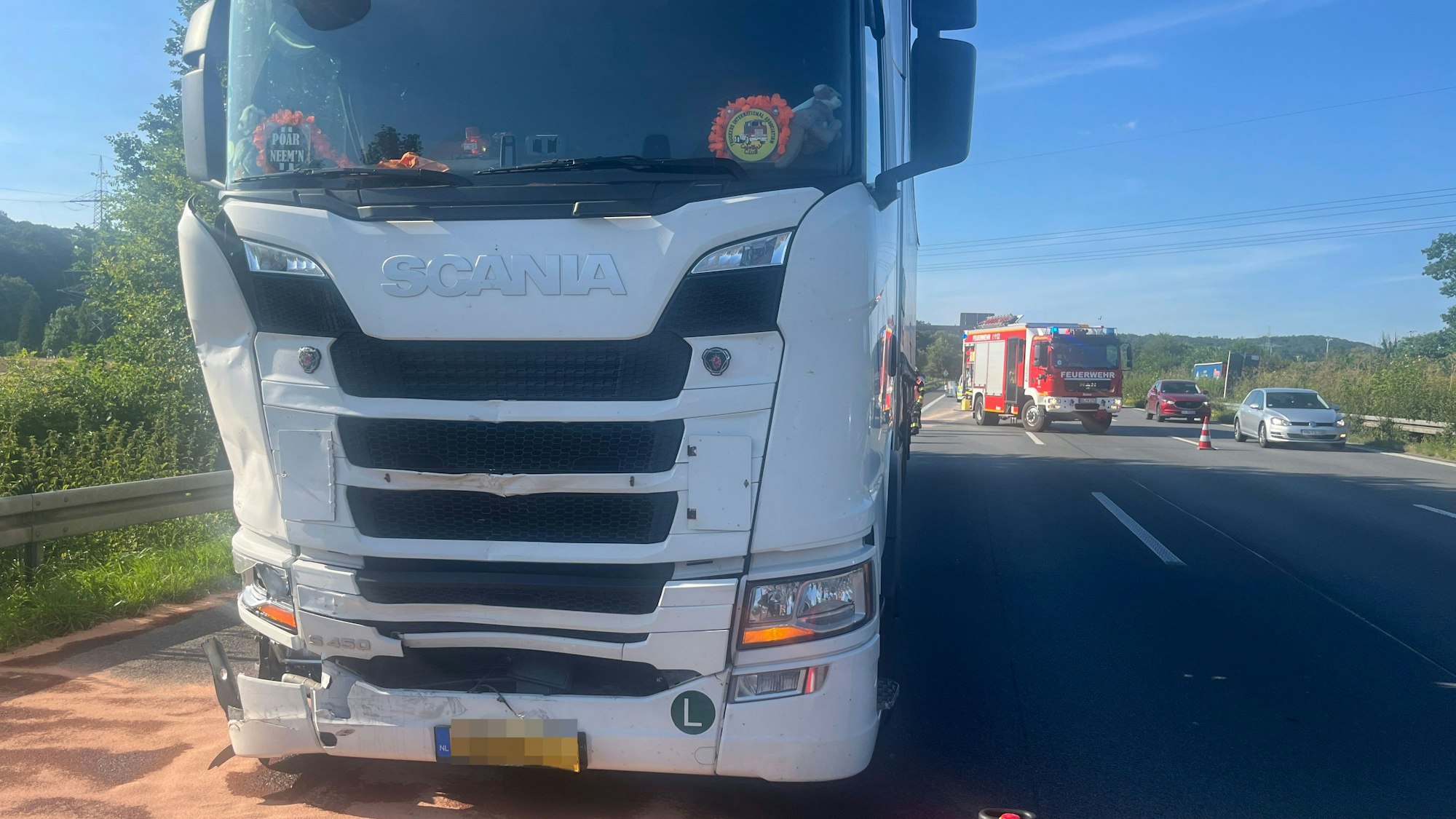 Ein Lastwagen ist an rechten Frontseite beschädigt, die Feuerwehr sichert die Unfallstelle ab.