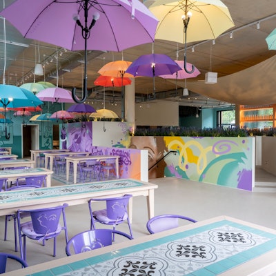 Regenschirme hängen in einem Restaurant über den Tischen.