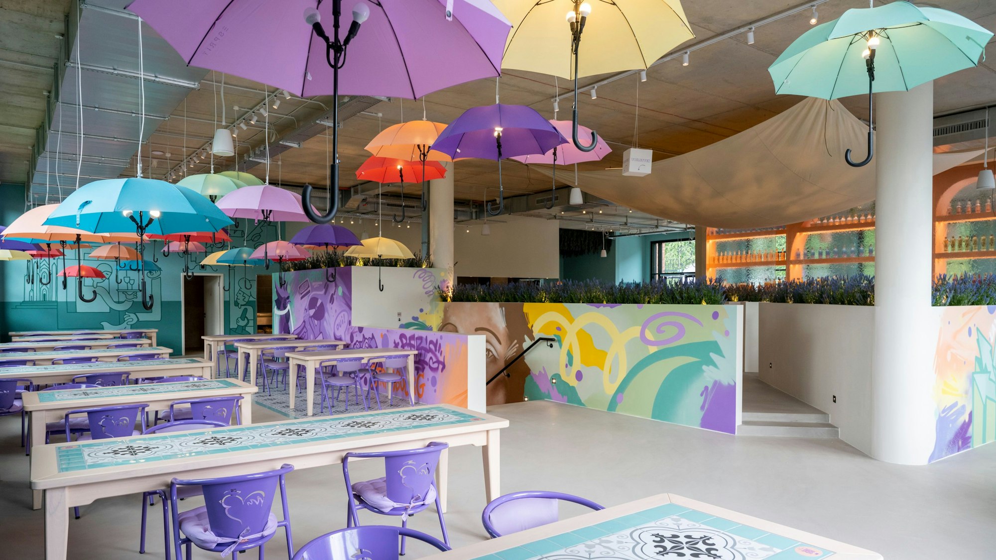 Regenschirme hängen in einem Restaurant über den Tischen.